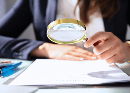 A woman going over a document with a magnifying glass