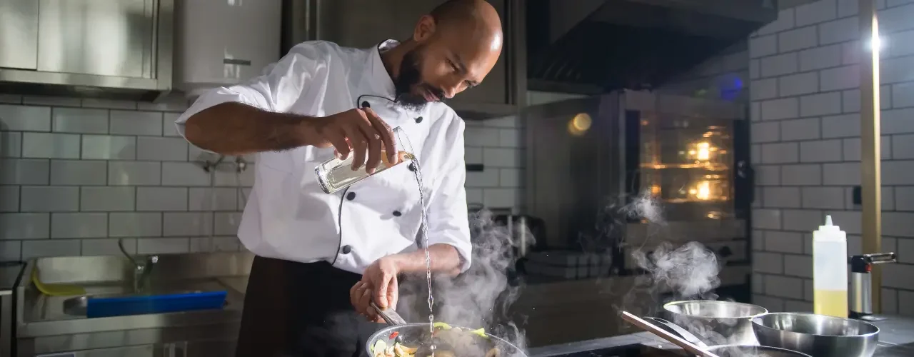 A cook preparing a meal in his kitchen.